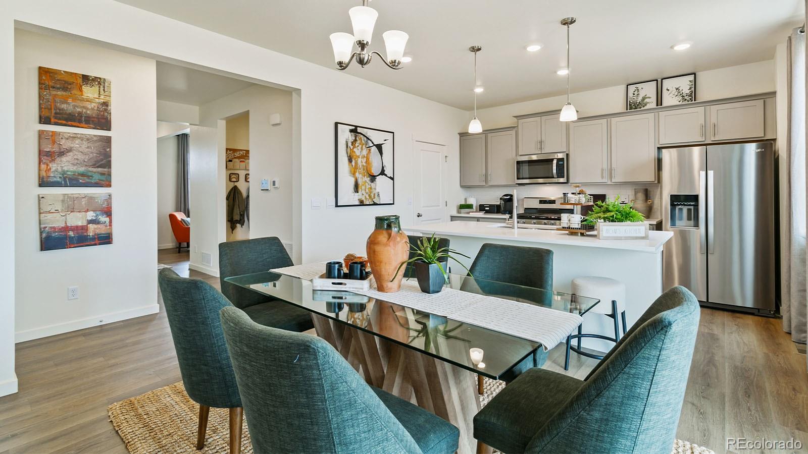 801 South Apex Avenue Fort Lupton, CO 80621 - Photo 9 of 26 a living room with stainless steel appliances kitchen island granite countertop furniture wooden floor and a kitchen view