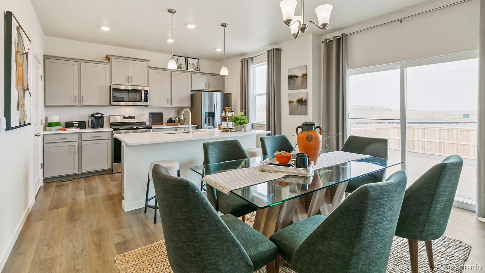 801 South Apex Avenue Fort Lupton, CO 80621 - Photo 10 of 26 a dining room with furniture a chandelier and wooden floor