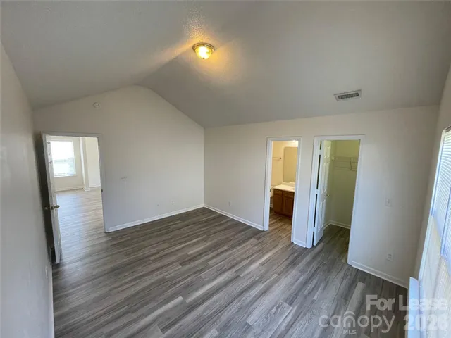 an empty room with wooden floor and mirror