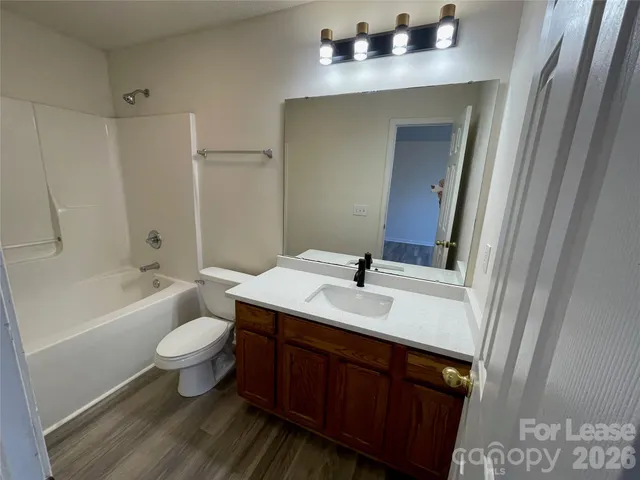 a bathroom with a bathtub shower sink vanity and toilet