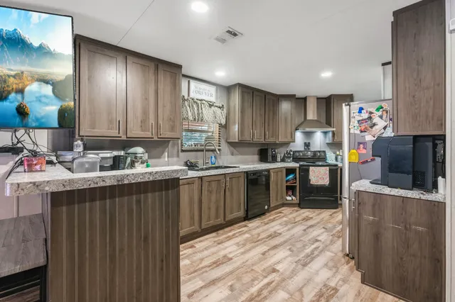 a kitchen with stainless steel appliances granite countertop a refrigerator stove and sink
