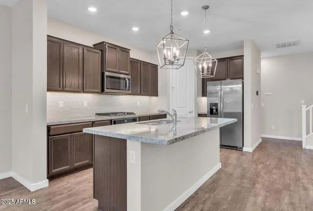 a large kitchen with stainless steel appliances kitchen island granite countertop a stove a sink and a refrigerator