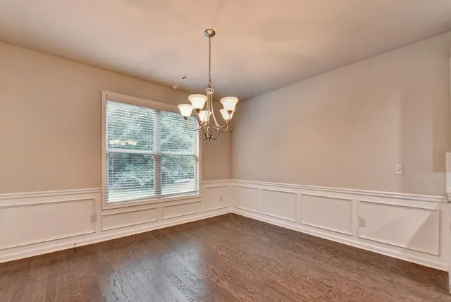 a view of a room with wooden floor and chandelier