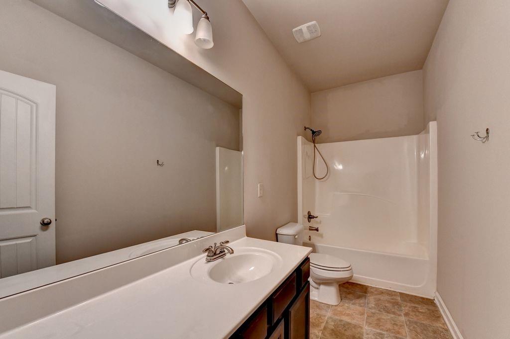 5166 Apple Grove Road Northeast Buford, GA 30519 - Photo 17 of 29 a bathroom with a sink a toilet and shower