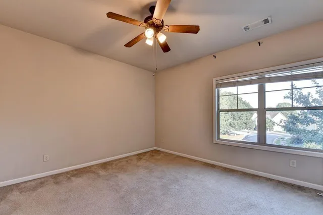 an empty room with a window and a fan