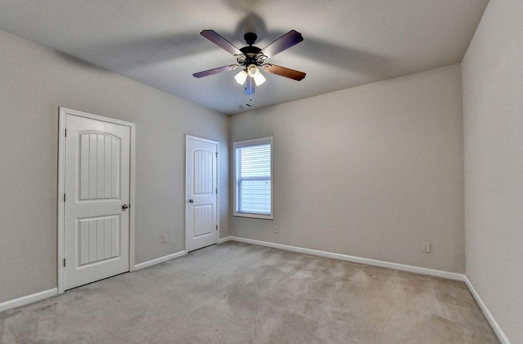 5166 Apple Grove Road Northeast Buford, GA 30519 - Photo 20 of 29 an empty room with ceiling fan and window