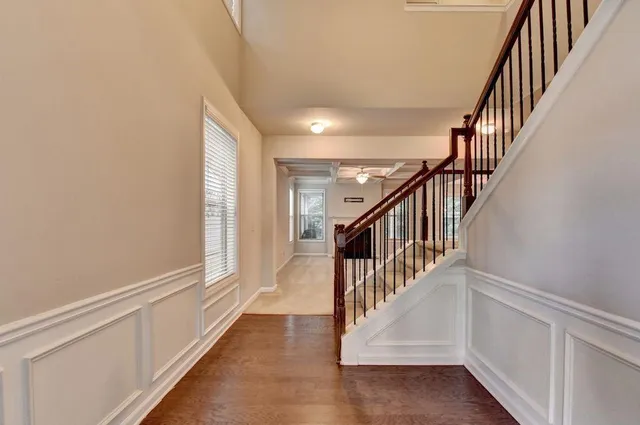 a view of staircase with wooden floor and white walls