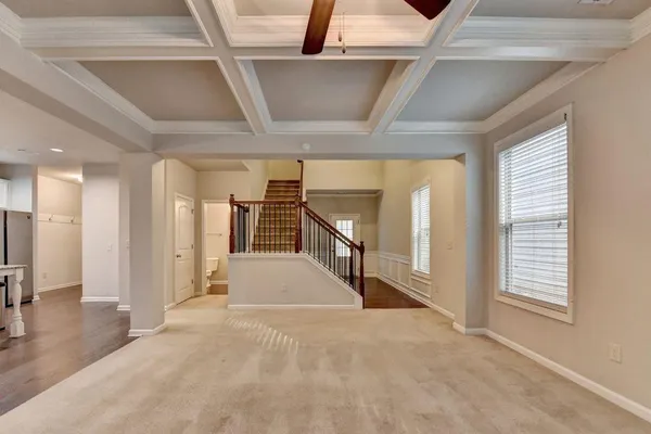 a view of a hallway with wooden floors and staircase