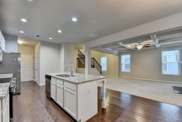 a kitchen with stainless steel appliances granite countertop a stove a refrigerator and a sink