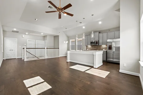 a view of kitchen with stainless steel appliances refrigerator oven microwave and cabinets