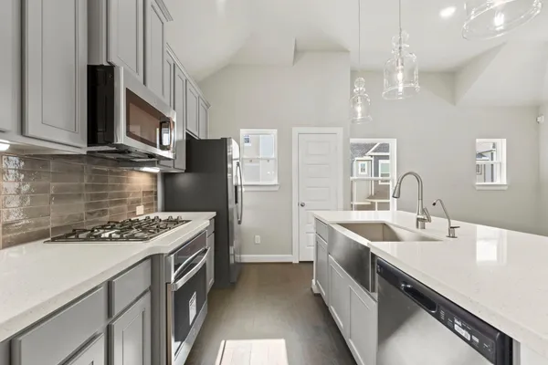 a kitchen with stainless steel appliances granite countertop a sink stove and refrigerator