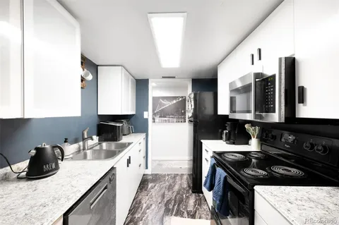 a kitchen with a sink stove top oven and cabinets