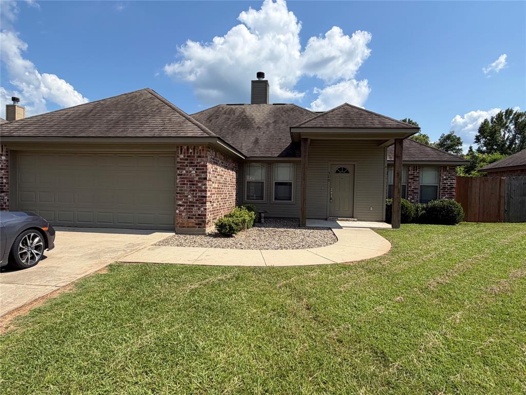 520 Big Red Circle Haughton, LA 71037 - Photo 22 of 25 Brick and siding exterior featuring a covered entry, attached garage, concrete driveway, and front lawn