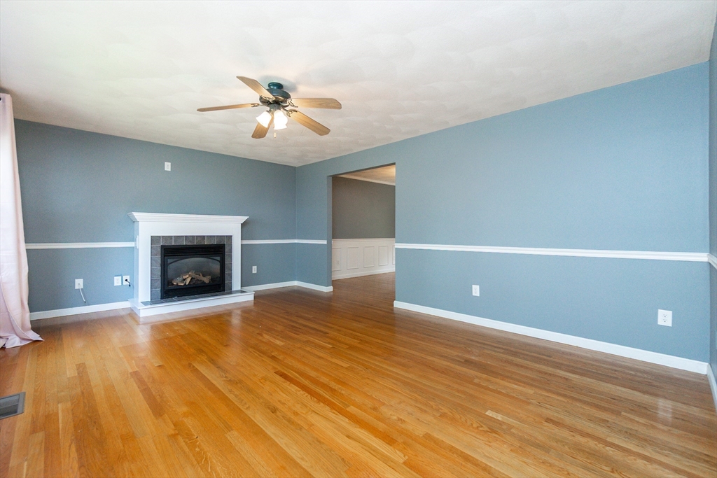 63 Bow Street Saugus, MA 01906 - Photo 4 of 42 wooden floor in an empty room with a fireplace