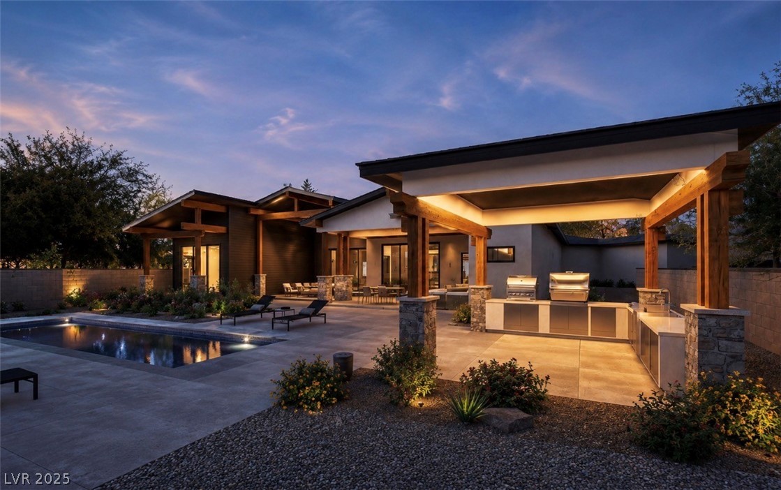 323 Wanda Road Henderson, NV 89002 - Photo 2 of 4 An inviting backyard oasis offers a sparkling pool and a fully equipped outdoor kitchen for memorable gatherings.