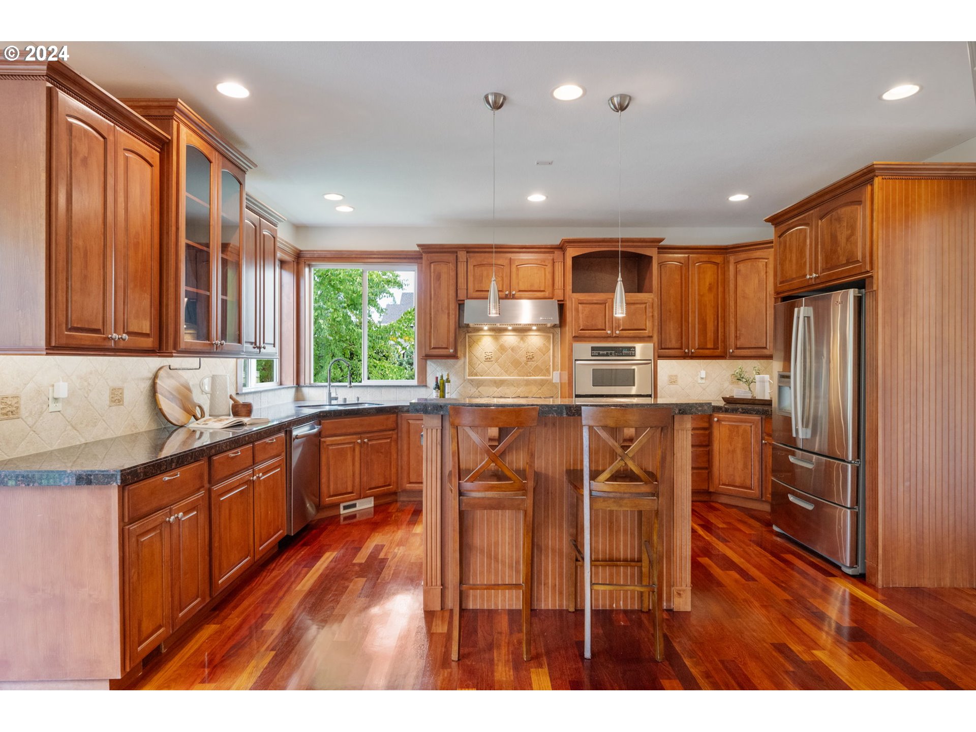 2204 South 17th Way Ridgefield, WA 98642 - Photo 5 of 45 a kitchen with stainless steel appliances granite countertop a refrigerator a sink dishwasher a stove with wooden cabinets and floor