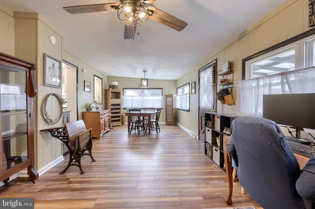 a dining room with wooden floor a chandelier a glass table and chairs
