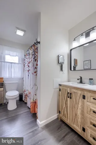 a bathroom with a toilet a sink and a mirror