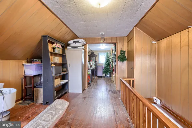 a view of a hallway with wooden floor and furniture