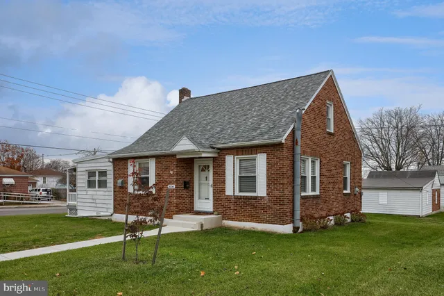 a front view of a house with a garden and yard