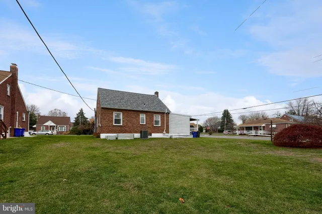 a view of a house with a big yard and large trees