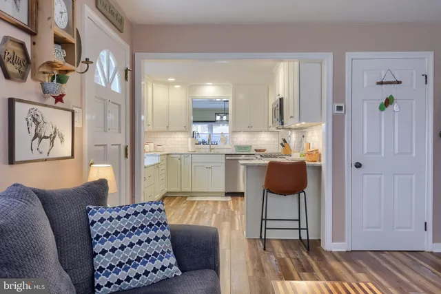 a living room with furniture a rug and kitchen view