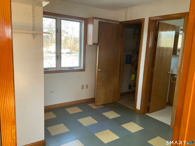 a view of a bedroom with wooden floor and a window