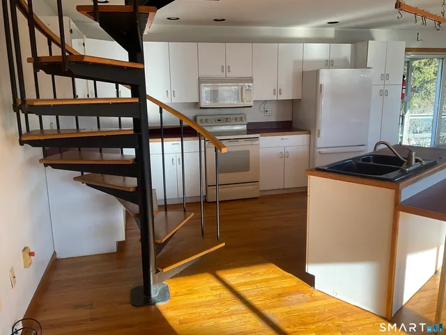 a kitchen with stainless steel appliances granite countertop a refrigerator a stove and a sink with cabinets