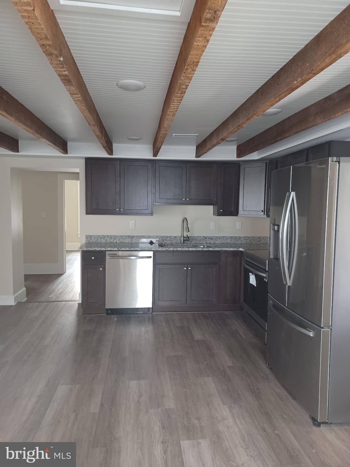 302 North Kent Street Winchester, VA 22601 - Photo 10 of 11 a kitchen with stainless steel appliances granite countertop a refrigerator a sink dishwasher a stove and white countertops with wooden floor
