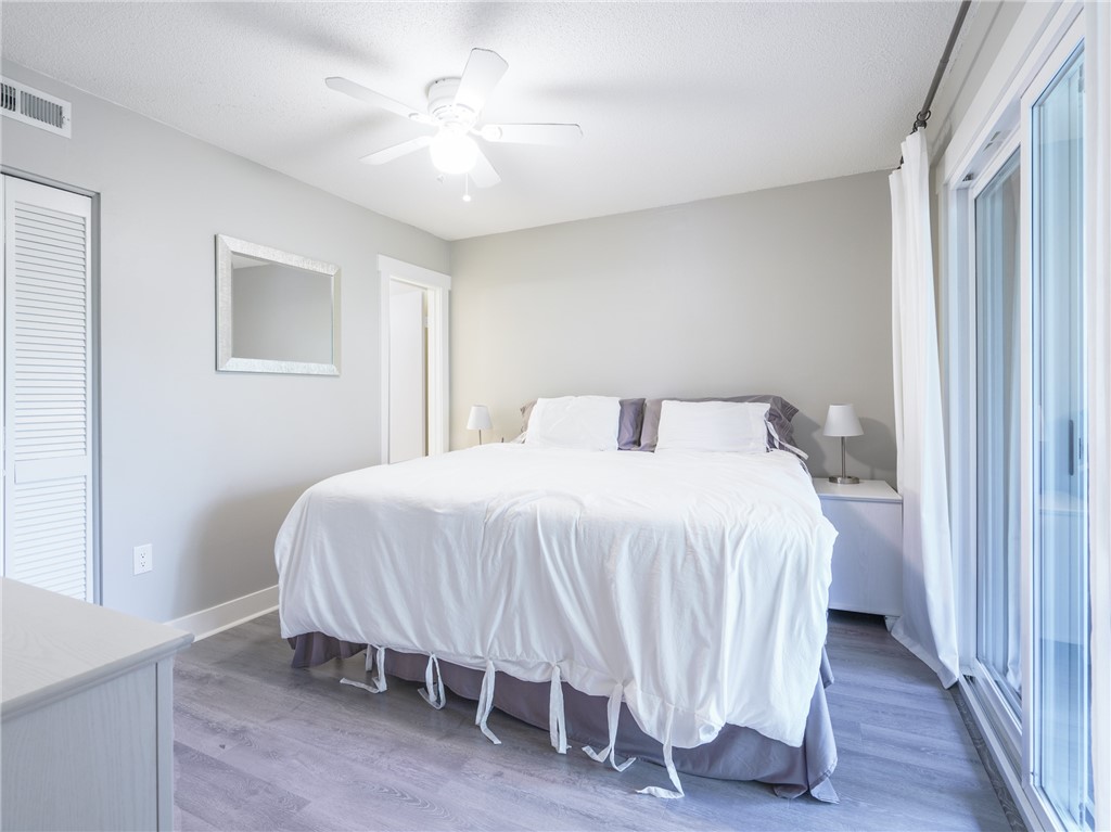 2328 Sadler Road, Unit 1E Fernandina Beach, FL 32034 - Photo 12 of 31 a bedroom with a bed and a chandelier