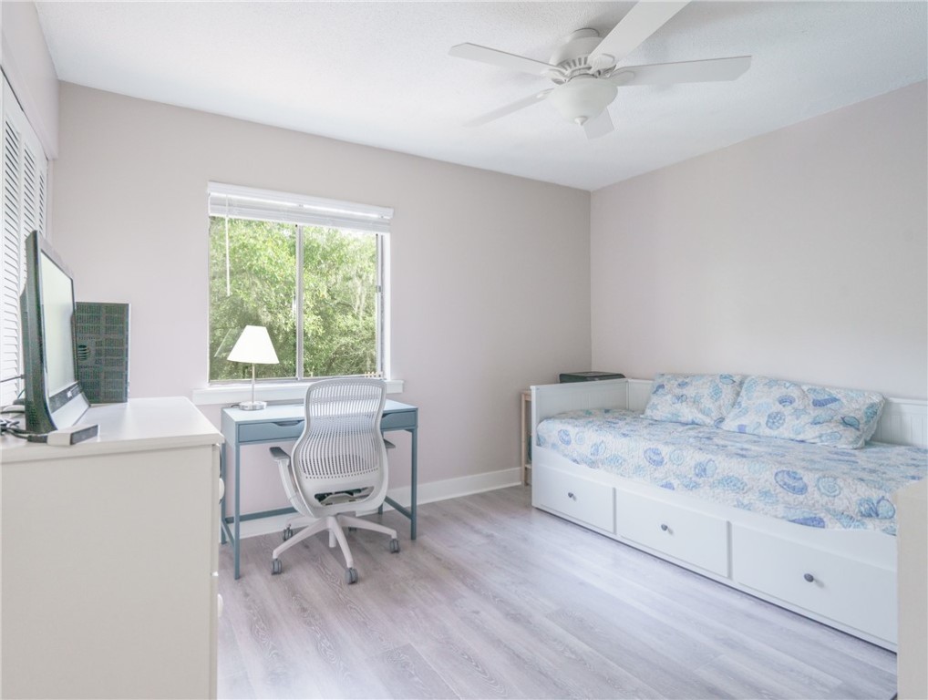 2328 Sadler Road, Unit 1E Fernandina Beach, FL 32034 - Photo 9 of 31 a bedroom with a bed a table and a chandelier