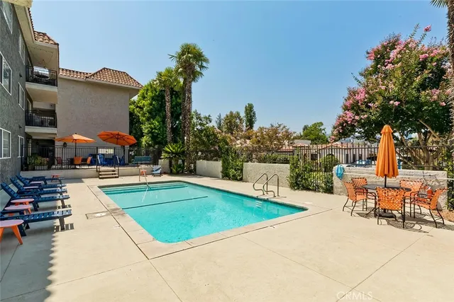 a swimming pool with outdoor seating and plants