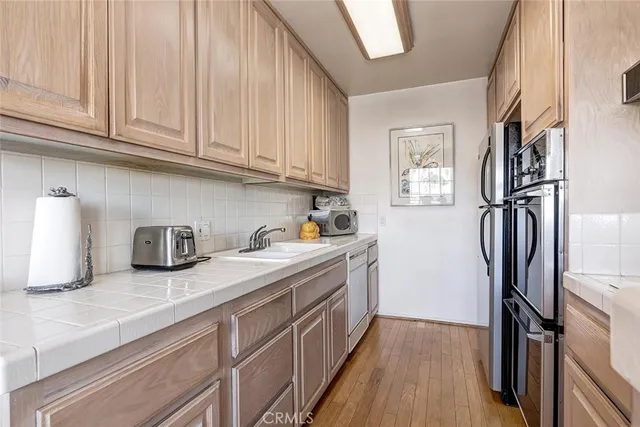 a kitchen with stainless steel appliances granite countertop a refrigerator and a sink