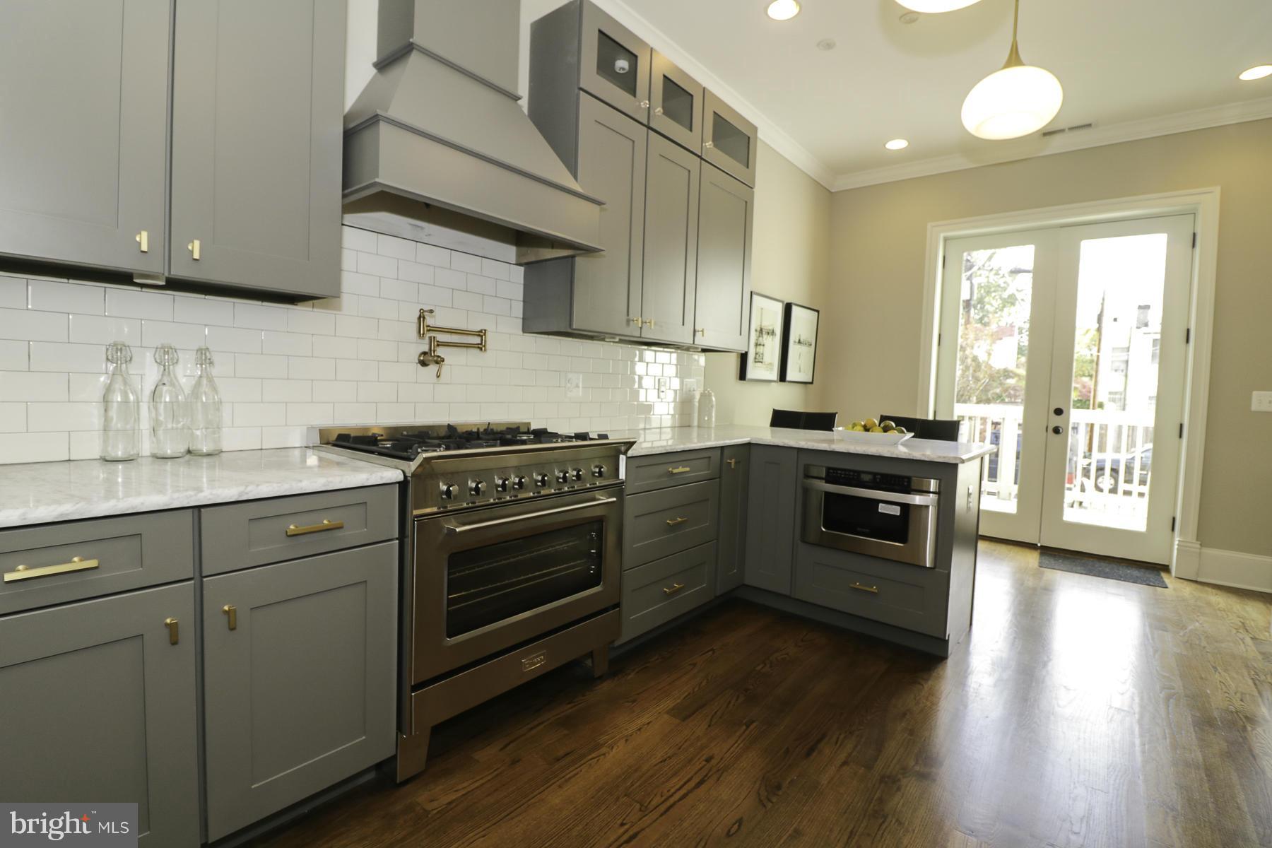 124 11th Street Northeast Washington, DC 20002 - Photo 10 of 30 a kitchen with stainless steel appliances white cabinets and a stove top oven