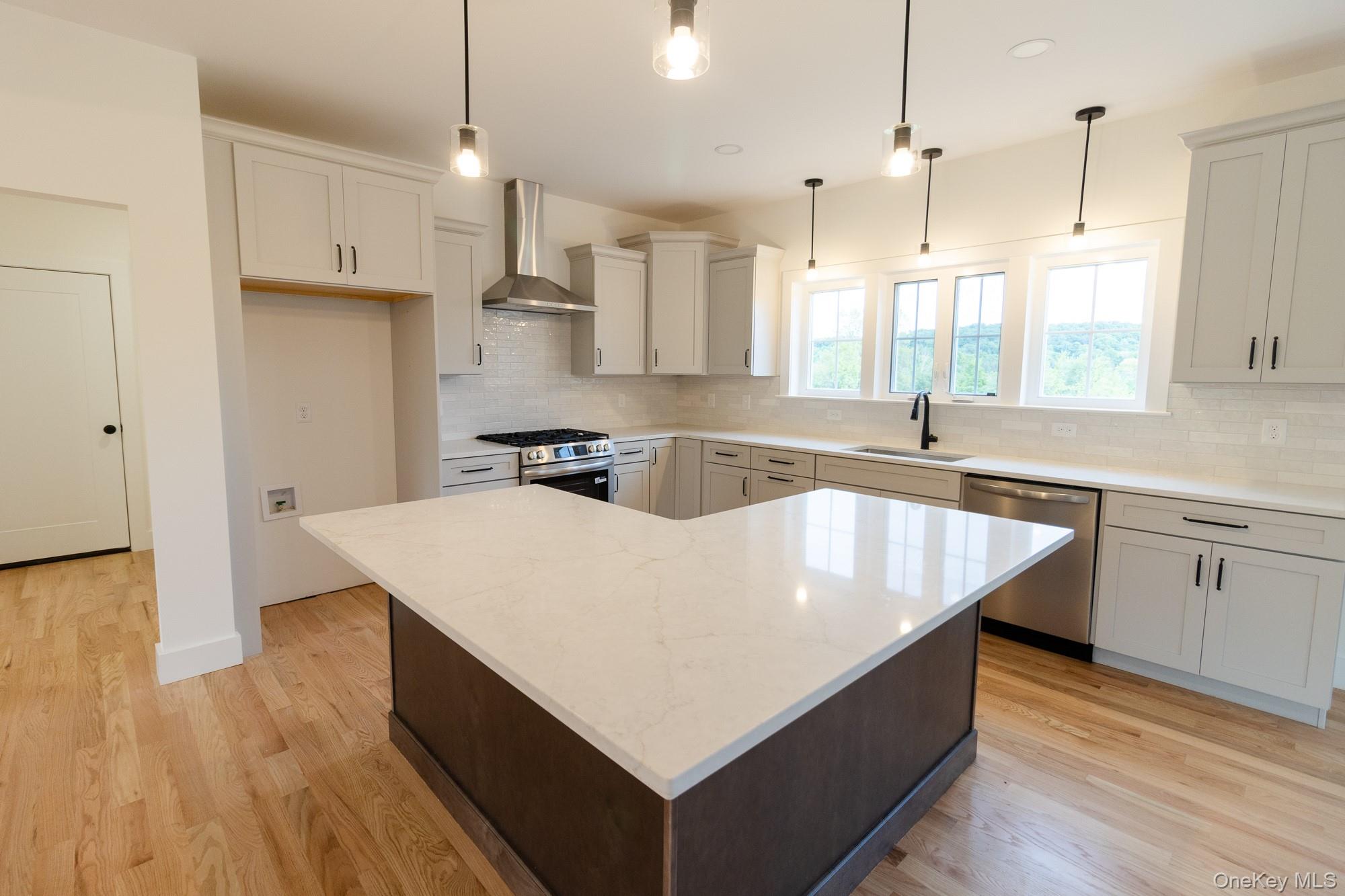 750 Ridgebury Road Slate Hill, NY 10973 - Photo 10 of 41 a kitchen with kitchen island a sink dishwasher a stove and white cabinets with wooden floor