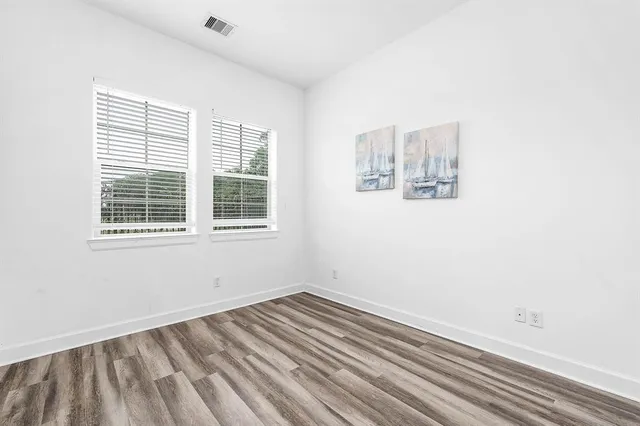 a view of a room with wooden floor and windows
