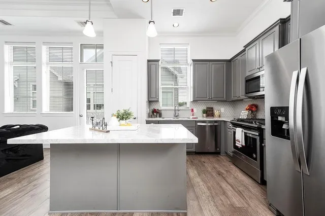 a kitchen with stainless steel appliances granite countertop a sink stove and refrigerator
