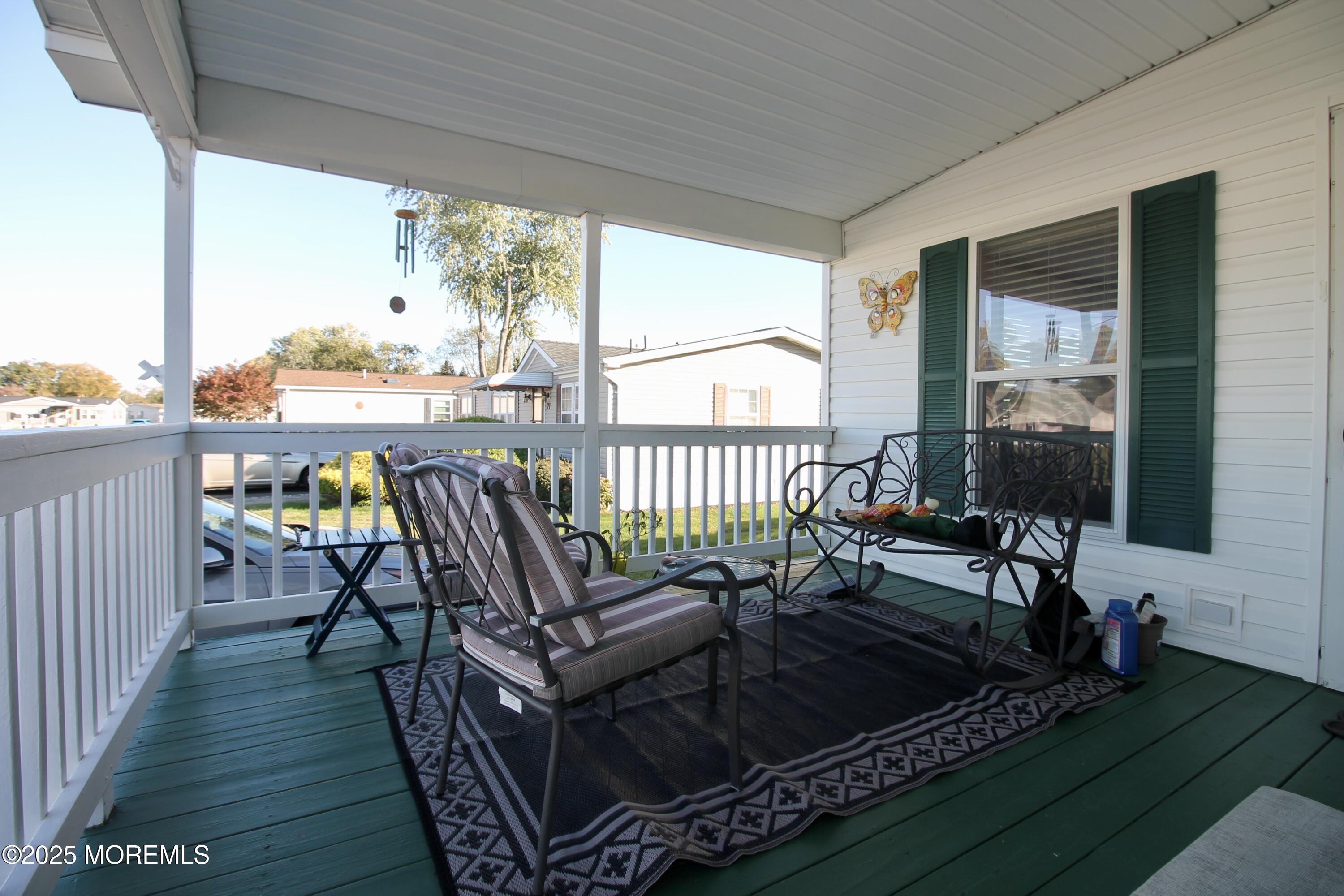 75 Robin Place Freehold, NJ 07728 - Photo 6 of 36 a balcony with wooden floor outdoor seating and yard