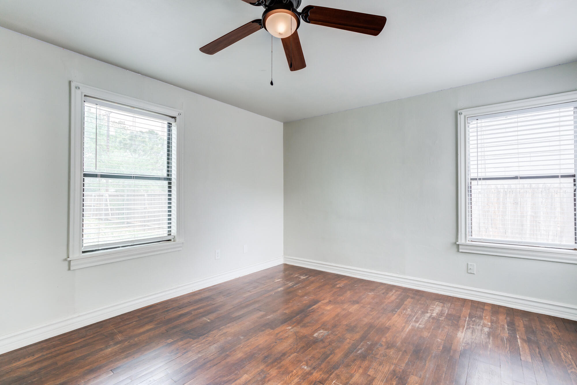 2308 30th Street Lubbock, TX 79411 - Photo 16 of 21 a view of an empty room with wooden floor and a window