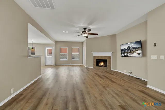 a view of an empty room with a fireplace and a window