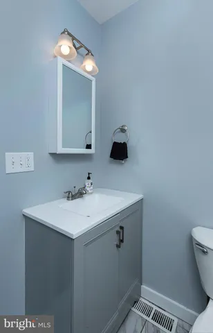 a bathroom with a sink a toilet and mirror