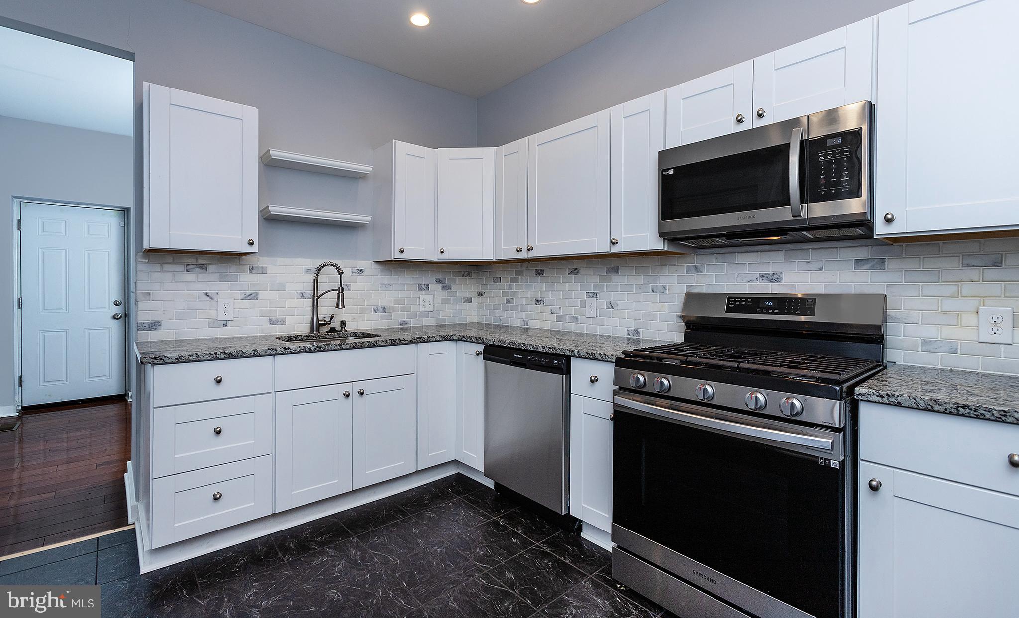 1750 North 25th Street Philadelphia, PA 19121 - Photo 10 of 37 a kitchen with stainless steel appliances granite countertop grey cabinets a stove a sink and dishwasher