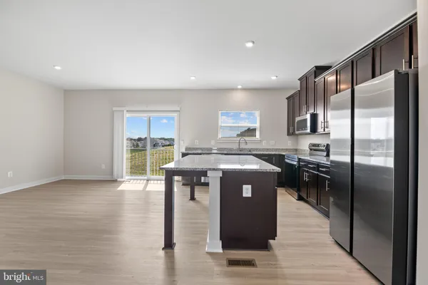 a kitchen with stainless steel appliances granite countertop a refrigerator a stove a sink and a refrigerator