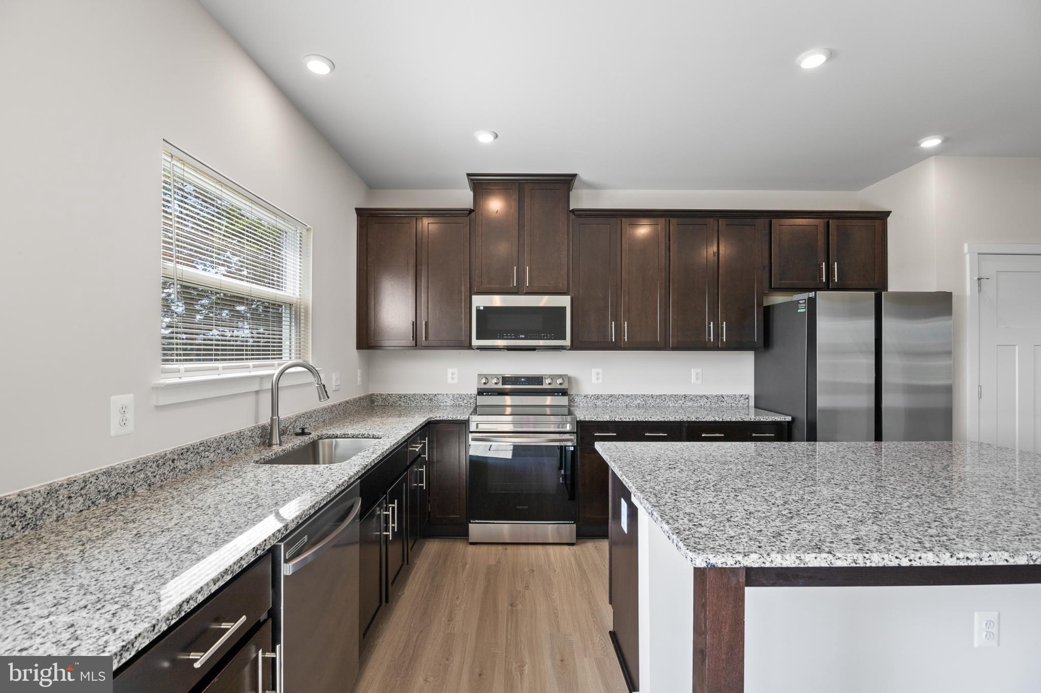 21 Lyriq Court Inwood, WV 25428 - Photo 20 of 40 a kitchen with stainless steel appliances granite countertop a sink stove and refrigerator