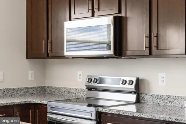 a kitchen with stainless steel appliances granite countertop white cabinets and a counter top
