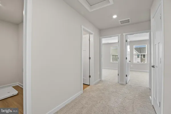 a view of a hallway with toilet and bathroom