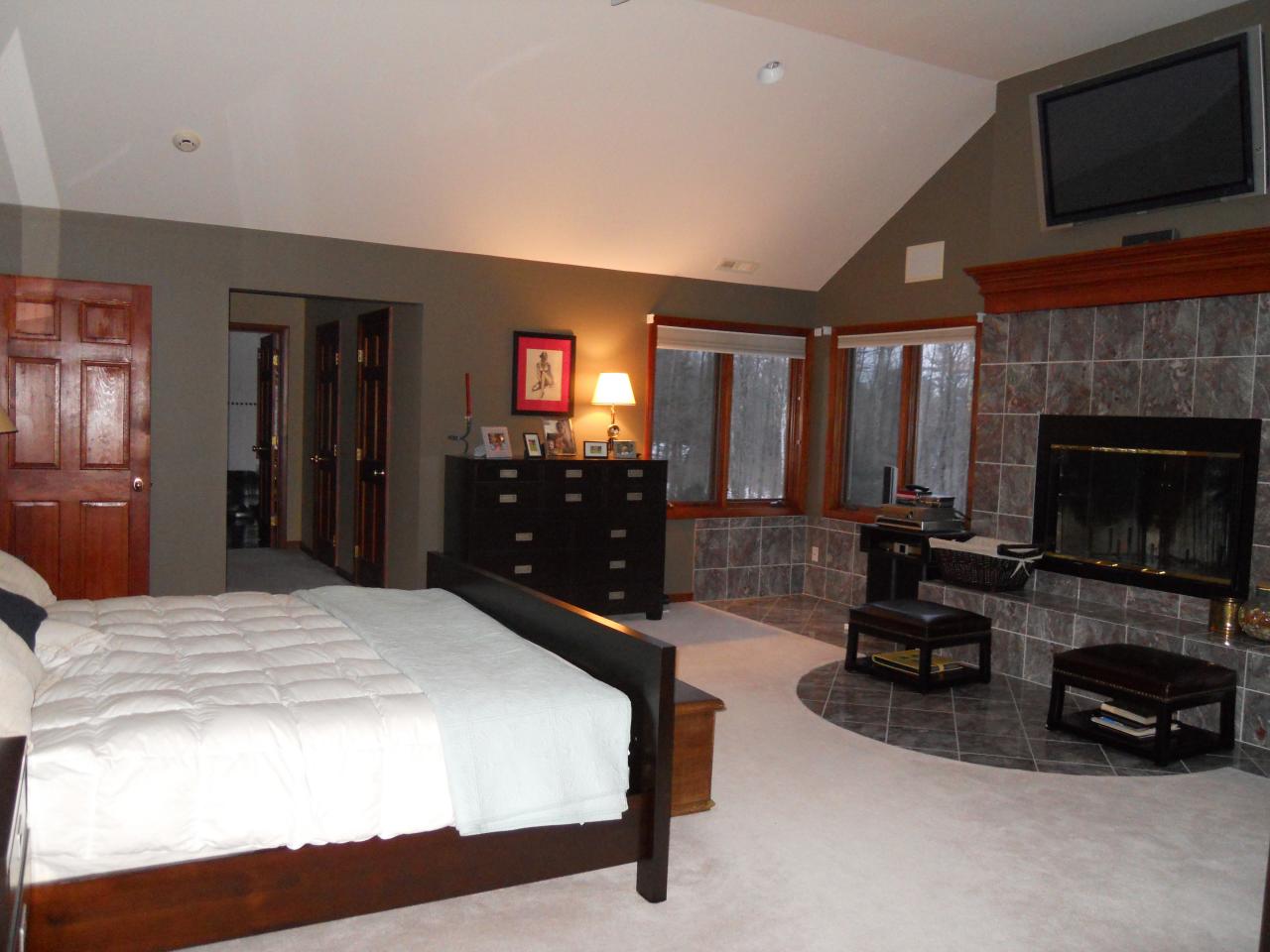 275 Hupi Road Monterey, MA 01245 - Photo 22 of 40 a bedroom with a bed a fireplace and a television
