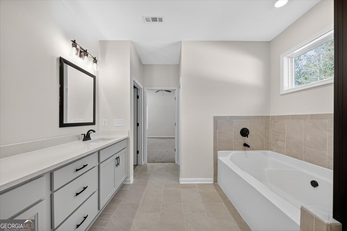 1570 The Rock Road Thomaston, GA 30286 - Photo 13 of 53 a bathroom with a tub a sink and mirror