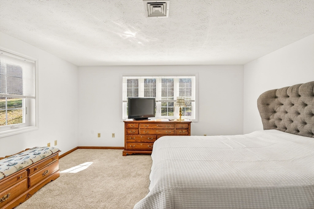 61 Fox Meadow Road, Unit A Leominster, MA 01453 - Photo 19 of 38 a bedroom with a bed and a flat screen tv