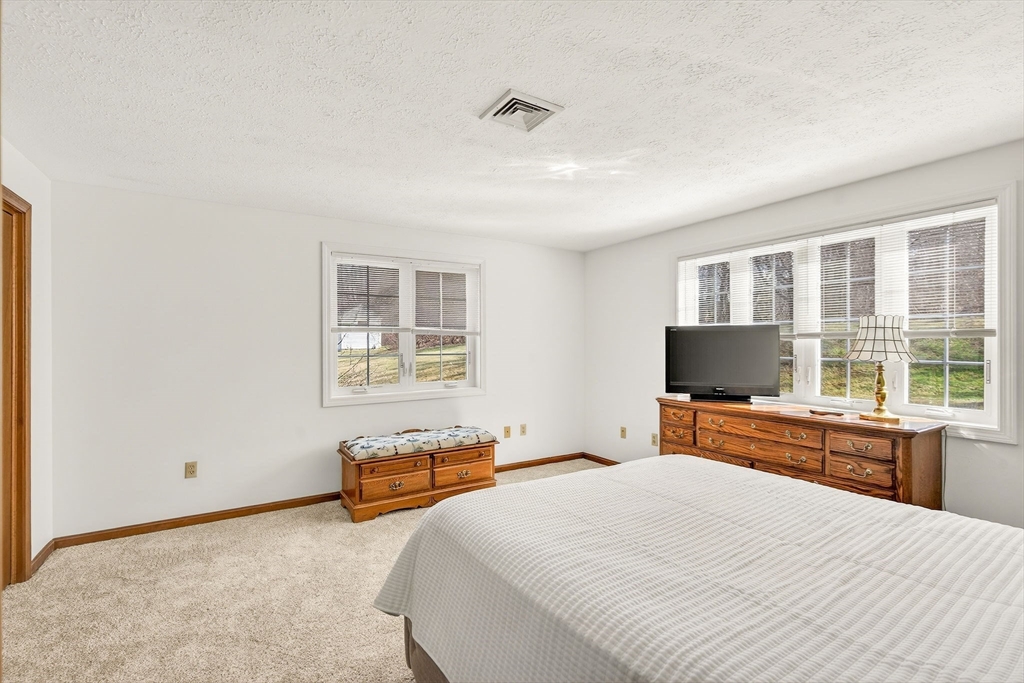 61 Fox Meadow Road, Unit A Leominster, MA 01453 - Photo 22 of 38 a bedroom with a bed and a flat tv screen on dresser